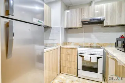 a kitchen with wooden cabinets and a stove at Ornate 2BR at Diamond Views 1, Jumeirah Village Circle by Deluxe Holiday Homes in Dubai