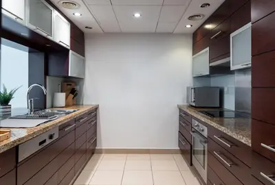a large kitchen with wooden cabinets and counters at Studio in Burj Views by Radiance Vacation Stays in Dubai