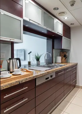 a kitchen with wooden cabinets and a counter top at Studio in Burj Views by Radiance Vacation Stays in Dubai