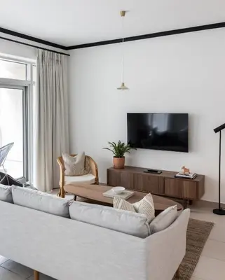 a living room with a white couch and a tv at Studio in Burj Views by Radiance Vacation Stays in Dubai