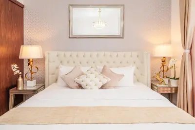 a bedroom with a large white bed with two tables at Elite Royal Apartment - Full Burj Khalifa & Fountain View - Magnum in Dubai
