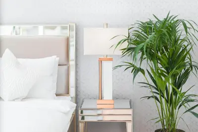 a bedroom with a bed and a lamp and a plant at Elite Royal Apartment - Full Burj Khalifa & Fountain View - Magnum in Dubai