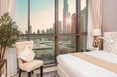 a hotel room with a bed and a large window at Elite Royal Apartment - Panoramic Full Burj Khalifa, Fountain & Skyline View - ACed direct connection to Dubai Mall - Governor in Dubai
