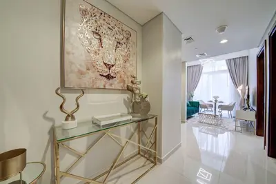a hallway with a glass table and a painting on the wall at Classic Arabian Elegance with City Views in Dubai