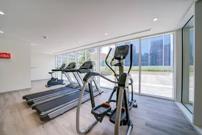 a gym with several treadmills and a row of exercise bikes at Classic Arabian Elegance with City Views in Dubai