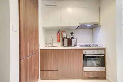 a kitchen with white cabinets and a stove top oven at Classic Arabian Elegance with City Views in Dubai