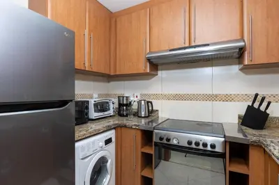 a kitchen with a stainless steel refrigerator and a dishwasher at 180° Sheik Zayed Road balcony views 2BR in JLT in Dubai