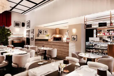 a restaurant with tables and chairs and a counter at Lusso Hometels J One Business Bay in Dubai