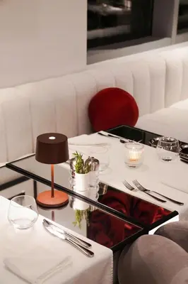 a table in a restaurant with white tables and chairs at Lusso Hometels J One Business Bay in Dubai