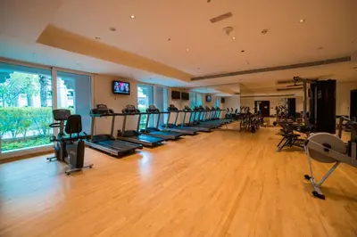 a gym with a row of treadmills and machines at 1-bedroom apartment with pool in Dubai