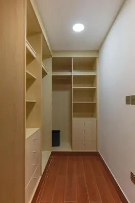 a walk in closet with white walls and wooden floors at 1-bedroom apartment with pool in Dubai