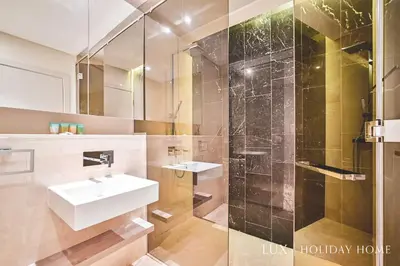 a bathroom with a sink and a shower at LUX - The Elegant Palm Beach Suite in Dubai