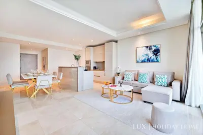 a living room with a couch and a table at LUX - The Elegant Palm Beach Suite in Dubai