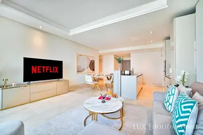 a living room with a tv on a wall at LUX - The Elegant Palm Beach Suite in Dubai