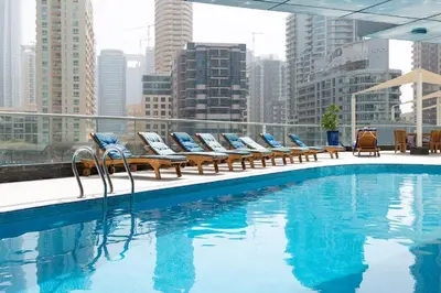 a pool with lounge chairs on the roof of a building at Frank Porter - The Point in Dubai