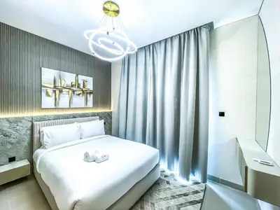 a bedroom with a white bed and a chandelier at STAY BY LATINEM Luxury 2BR Holiday Home CV B2513 near Burj Khalifa in Dubai