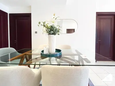 a glass table with a vase of flowers on it at Luxury 2Bedroom in Dubai Old Town with Burj View in Dubai