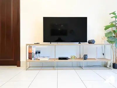 a television on top of a glass entertainment center at Luxury 2Bedroom in Dubai Old Town with Burj View in Dubai