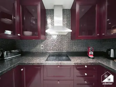 a kitchen with purple cabinets and a white hood at Luxury 2Bedroom in Dubai Old Town with Burj View in Dubai