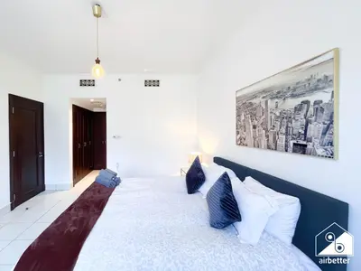 a bedroom with a large bed with blue and white pillows at Luxury 2Bedroom in Dubai Old Town with Burj View in Dubai