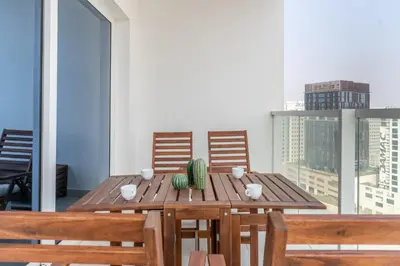 a wooden table with chairs and a cactus on a balcony at GuestReady - Stylish Apt in Business Bay in Dubai