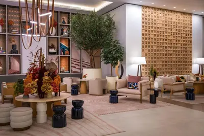 a lobby with chairs and a table and plants at Vida Dubai Marina & Yacht Club in Dubai