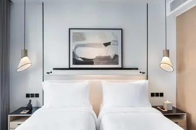 two beds in a hotel room with two lamps at Vida Dubai Marina & Yacht Club in Dubai