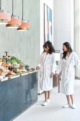 two women standing in a kitchen preparing food at Vida Dubai Marina & Yacht Club in Dubai