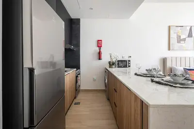 a kitchen with a large stainless steel refrigerator at Frank Porter - Regina Tower in Dubai
