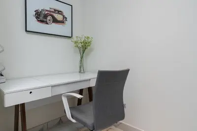 a desk with a chair and a picture of a car at White Sage - Amna Tower in Dubai