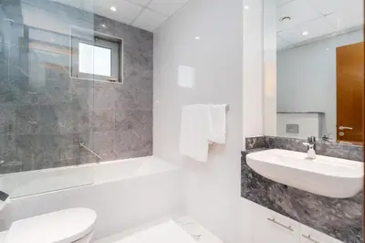 a bathroom with a sink and a tub and a toilet at White Sage - Amna Tower in Dubai
