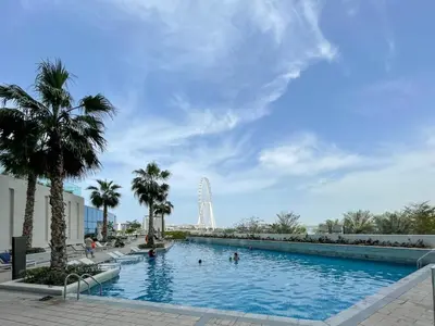 a large swimming pool with a ferris wheel in the background at 72 floor 2BR at the Address JBR with Marina Views! in Dubai