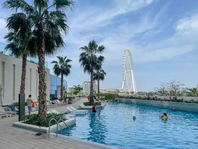 a swimming pool with a ferris wheel in the background at 72 floor 2BR at the Address JBR with Marina Views! in Dubai