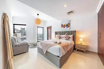 a bedroom with a bed and a couch and a chair at Spacious 3BR with 180˚ Dubai Marina Views in Dubai