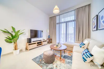 a living room with a couch and a tv at Sophisticated 1BR at Town Square Rawda Dubailand by Deluxe Holiday Homes in Dubai