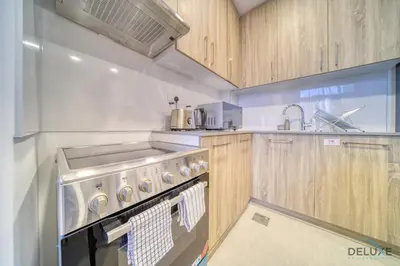 a kitchen with a sink and a stove top oven at Sophisticated 1BR at Town Square Rawda Dubailand by Deluxe Holiday Homes in Dubai