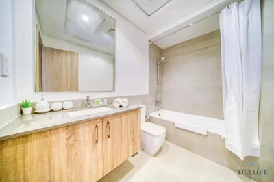 a bathroom with a sink and a tub and a toilet at Sophisticated 1BR at Town Square Rawda Dubailand by Deluxe Holiday Homes in Dubai