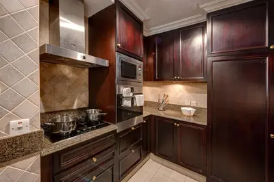 a kitchen with wooden cabinets and a stove top oven at Durrani Homes - Heaven on Earth in Dubai