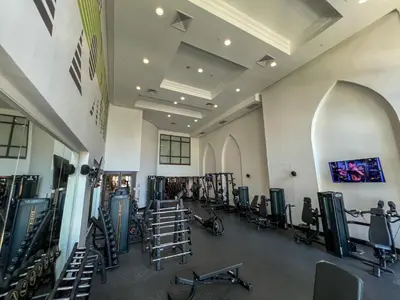 a gym with rows of exercise bikes and treadmills at Durrani Homes - Heaven on Earth in Dubai