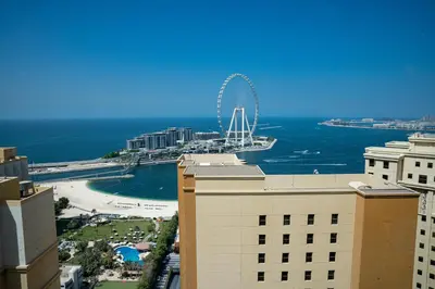 a view of a city with a ferris wheel in the ocean at Luxury Casa - Platinum Sea View Apartment 2BR at JBR Beach in Dubai