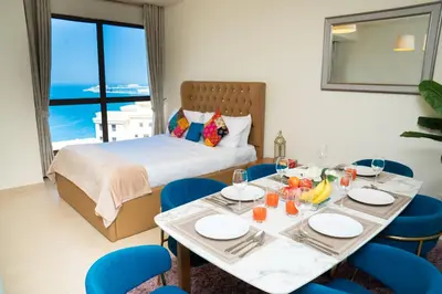 a room with a table and chairs and a bed at Luxury Casa - Platinum Sea View Apartment 2BR at JBR Beach in Dubai