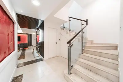 a staircase in a home with white walls and a red wall at Elan Suites 5-Bedroom Beach Villa in Dubai
