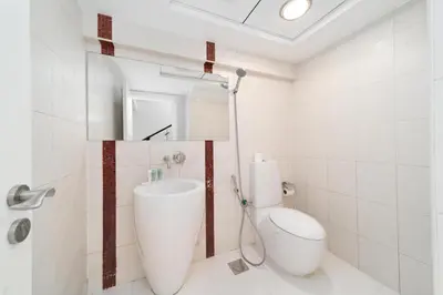 a white bathroom with a toilet and a mirror at Elan Suites 5-Bedroom Beach Villa in Dubai