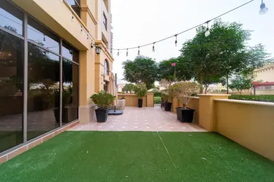 a patio with green grass outside of a building at Elan Suites 5-Bedroom Beach Villa in Dubai