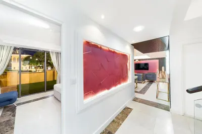 a living room with a large red painting on the wall at Elan Suites 5-Bedroom Beach Villa in Dubai