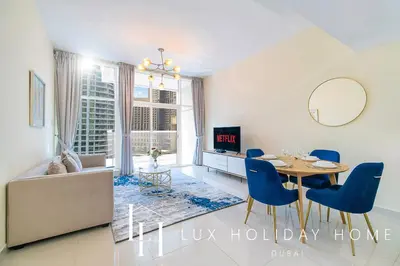 a dining room with a table and blue chairs at LUX Marina View Prime Location Near Beach in Dubai