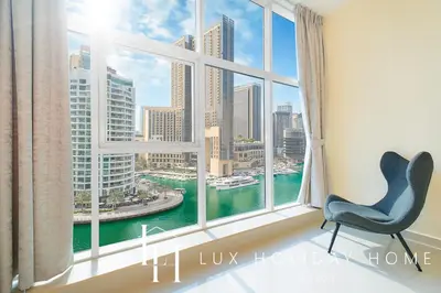a chair in a room with a large window at LUX Marina View Prime Location Near Beach in Dubai