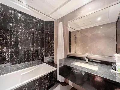 a bathroom with a sink and a tub and a mirror at Luxury Burj Khalifa View Studio Elite Downtown - 18AB19AB03 in Dubai