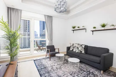 a living room with a couch and a large window at Beautiful & Bright 2BR + kids - 7min to Dubai Mall in Dubai