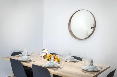a table with a mirror and a table with chairs at Beautiful & Bright 2BR + kids - 7min to Dubai Mall in Dubai